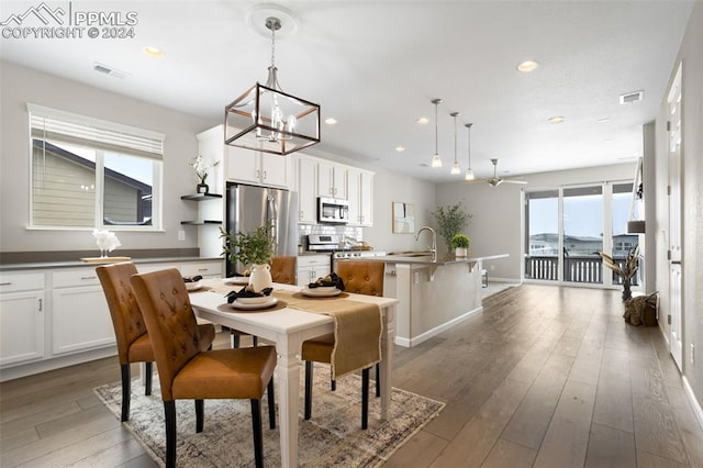 dining room featuring dark wood-type flooring, sink, and an inviting chandelier