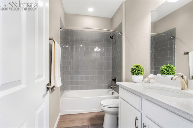 full bathroom featuring wood-type flooring, vanity, toilet, and tiled shower / bath combo