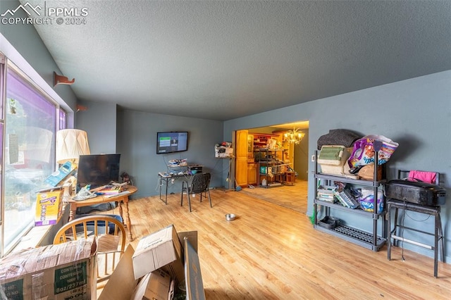 living room featuring hardwood / wood-style flooring, a textured ceiling, and a chandelier