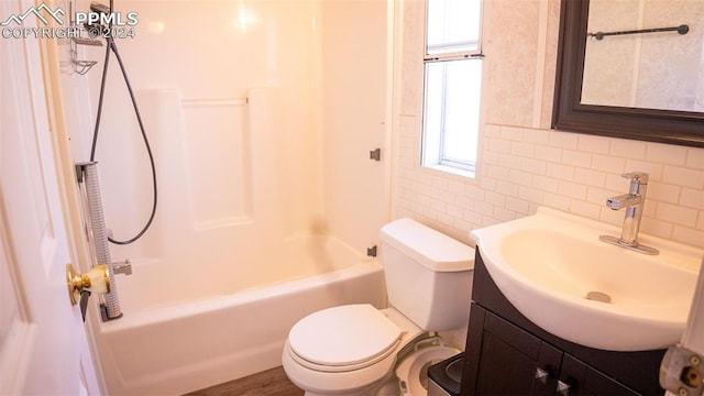 full bathroom featuring vanity, toilet, tile walls, and tub / shower combination