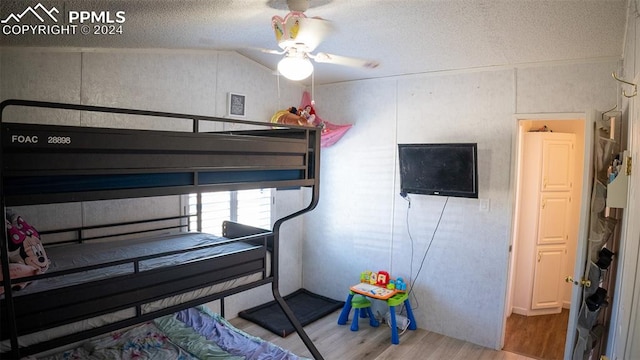 bedroom with ceiling fan, a textured ceiling, and light wood-type flooring