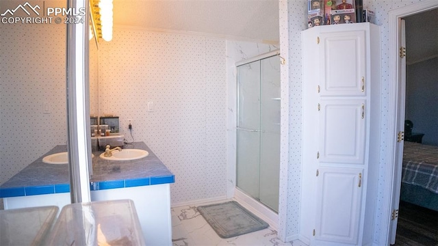 bathroom with vanity, ornamental molding, and an enclosed shower