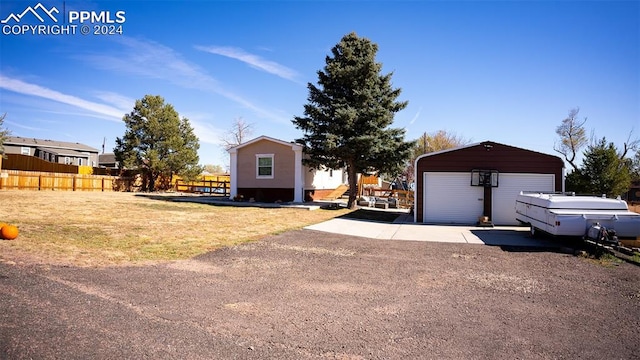 view of front of home featuring a front lawn, an outbuilding, and a garage