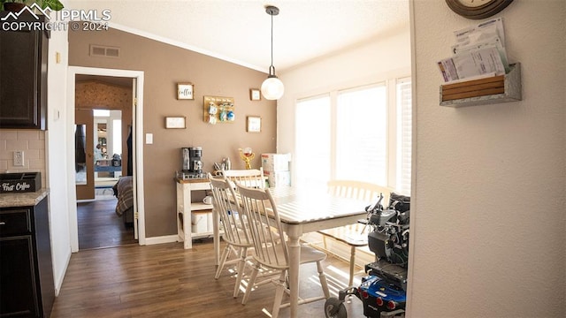 dining area with lofted ceiling and dark wood-type flooring