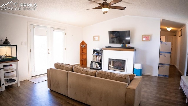 living room with lofted ceiling, ceiling fan, a textured ceiling, and dark hardwood / wood-style flooring