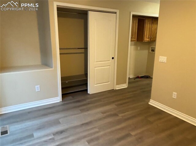 unfurnished bedroom featuring a closet and hardwood / wood-style floors