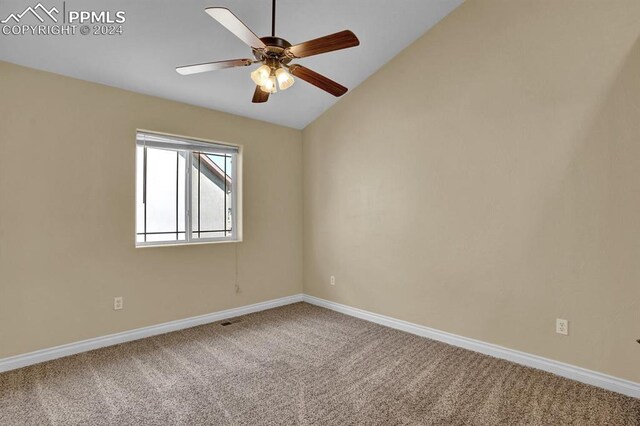 carpeted spare room with ceiling fan and lofted ceiling