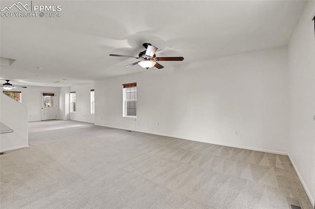 unfurnished room with light carpet and ceiling fan