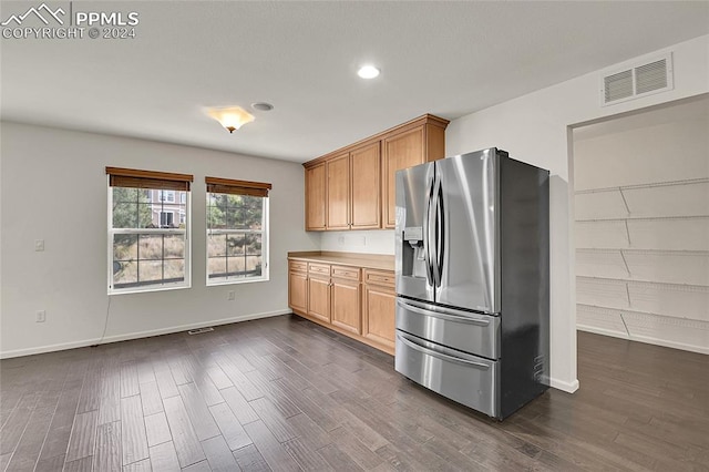 kitchen featuring light brown cabinets, dark hardwood / wood-style floors, and stainless steel fridge