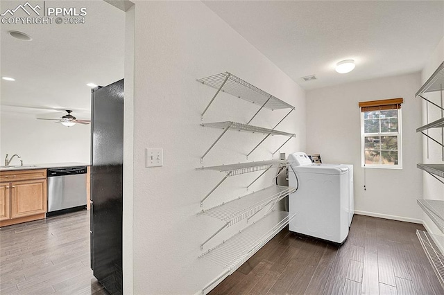 laundry area featuring ceiling fan, sink, separate washer and dryer, and dark hardwood / wood-style flooring