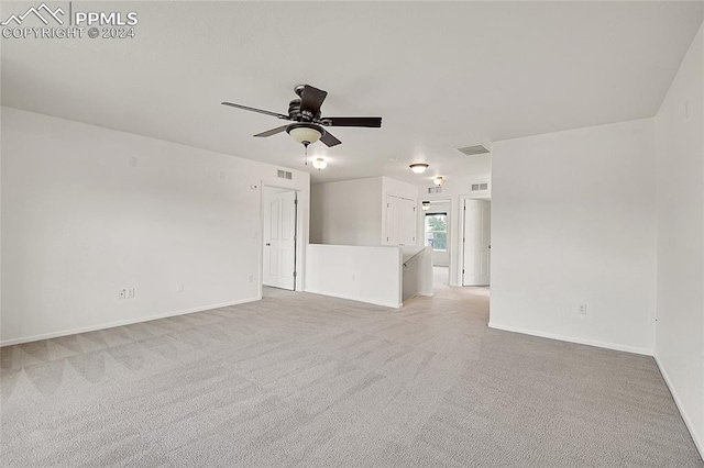 carpeted spare room featuring ceiling fan