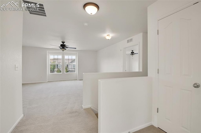 hallway featuring light colored carpet