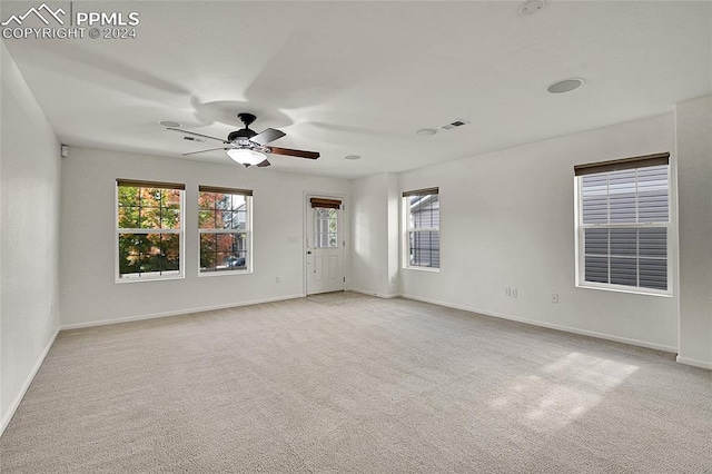 unfurnished room with ceiling fan and light carpet