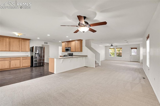 unfurnished living room featuring ceiling fan and dark hardwood / wood-style flooring