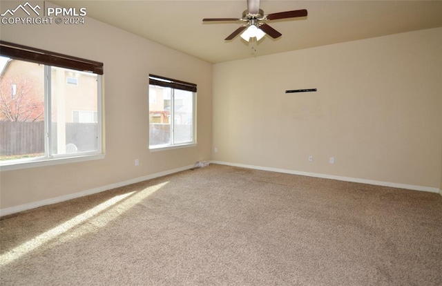 carpeted spare room featuring ceiling fan