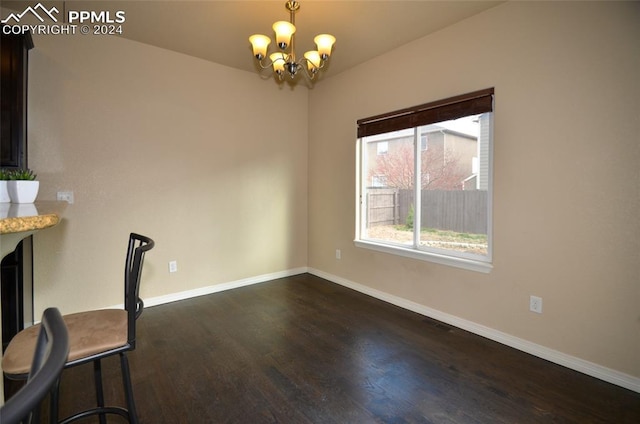 unfurnished dining area featuring an inviting chandelier and dark wood-type flooring