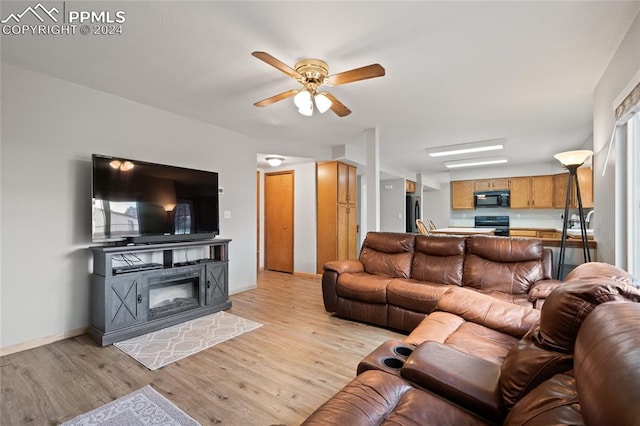 living room with light wood-type flooring and ceiling fan