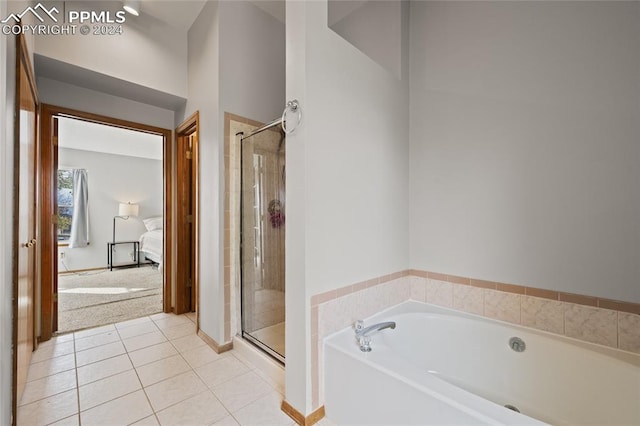 bathroom featuring tile patterned flooring and separate shower and tub