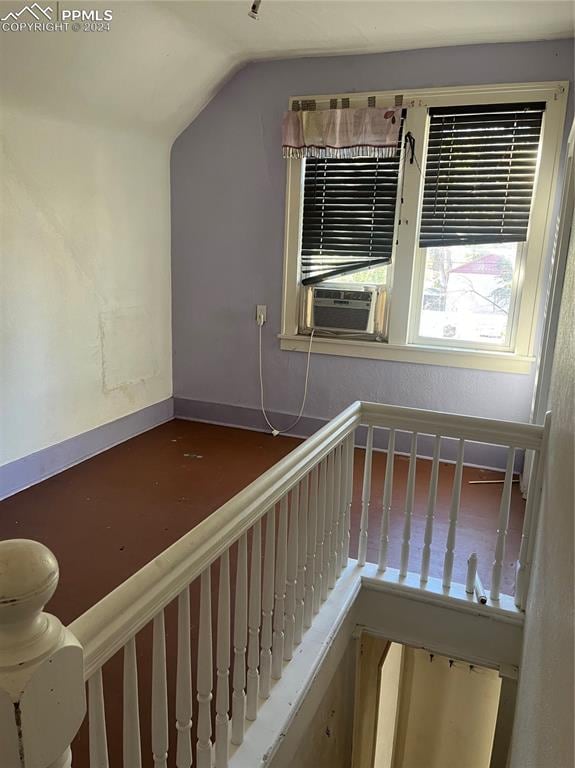 stairway featuring cooling unit and lofted ceiling