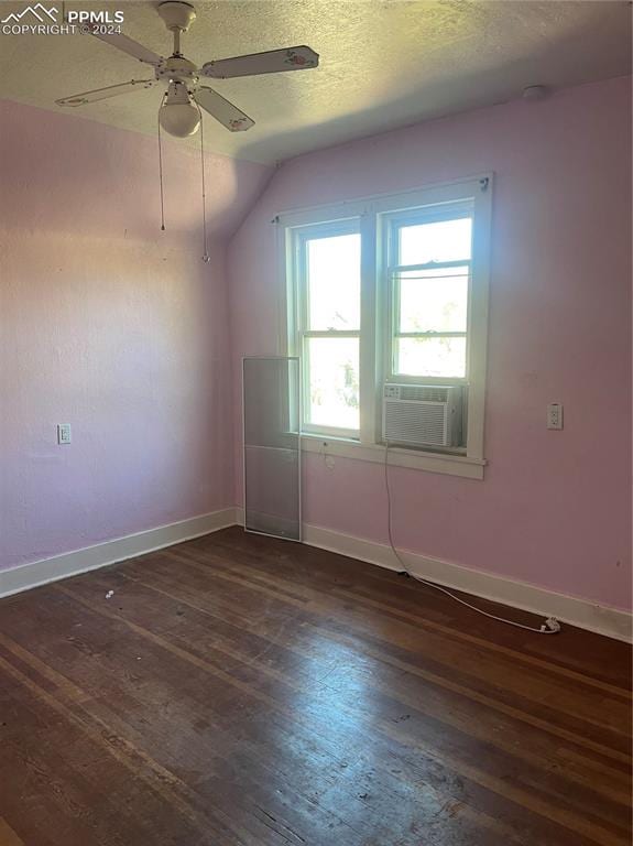 additional living space featuring cooling unit, a textured ceiling, dark wood-type flooring, lofted ceiling, and ceiling fan