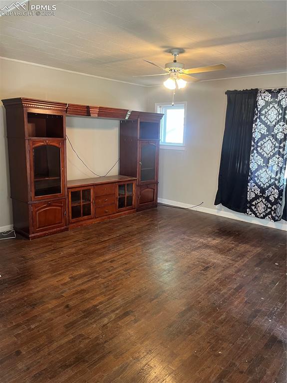 unfurnished living room featuring dark hardwood / wood-style floors and ceiling fan