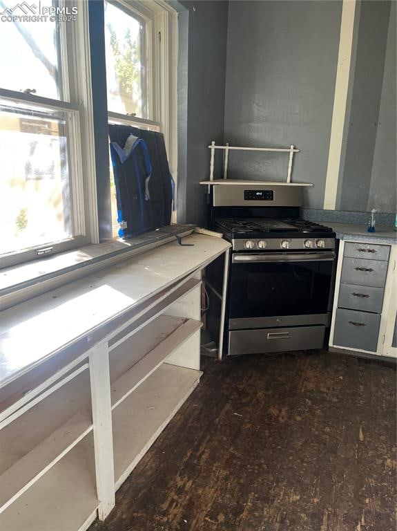 kitchen with dark hardwood / wood-style floors and stainless steel range with gas cooktop