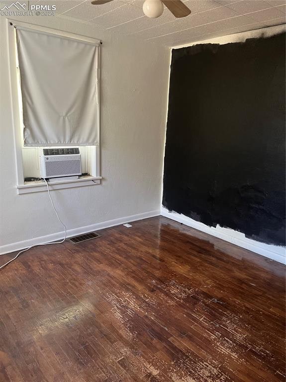 empty room with hardwood / wood-style floors, ceiling fan, and cooling unit