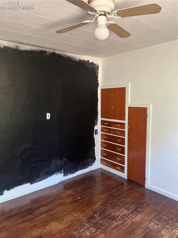 spare room featuring dark hardwood / wood-style flooring and ceiling fan