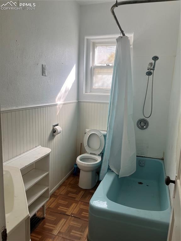 bathroom featuring parquet flooring and toilet