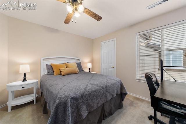 bedroom featuring ceiling fan, light colored carpet, and multiple windows