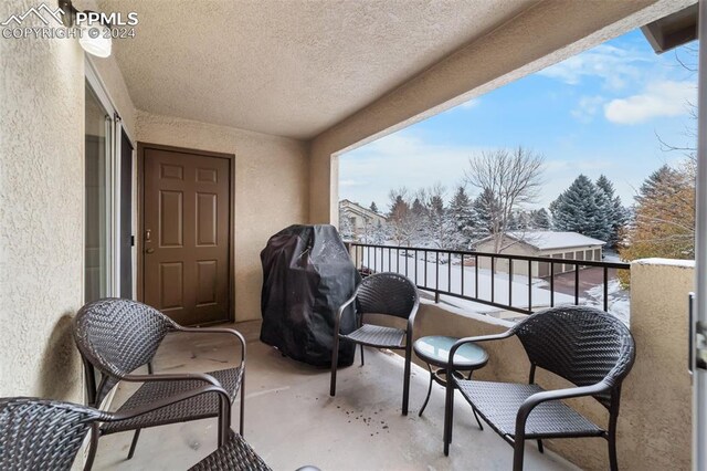 snow covered back of property featuring grilling area