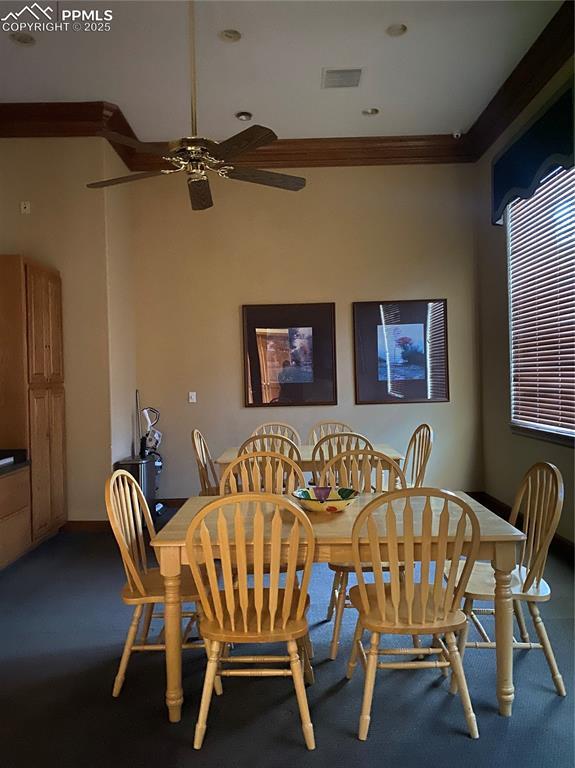 carpeted dining area featuring ceiling fan and ornamental molding