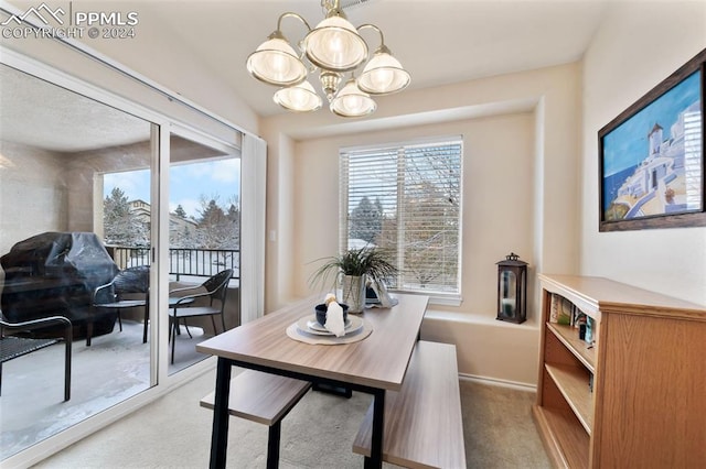 carpeted dining area with an inviting chandelier