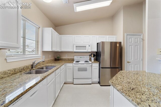 kitchen featuring lofted ceiling, sink, white appliances, light stone countertops, and white cabinets