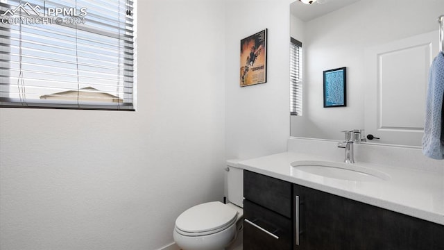 bathroom featuring plenty of natural light, vanity, and toilet