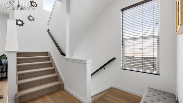 stairs featuring hardwood / wood-style floors