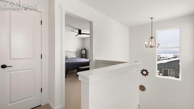 hallway featuring carpet floors and an inviting chandelier