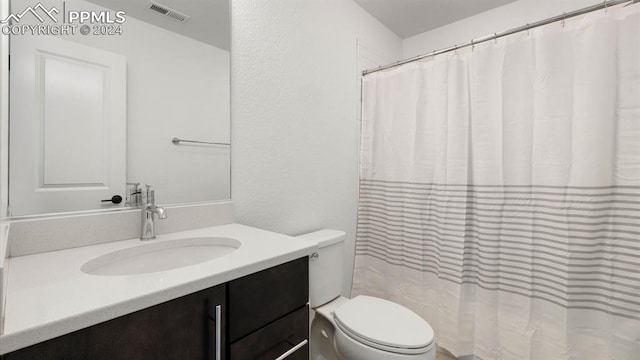 bathroom with a shower with curtain, vanity, and toilet