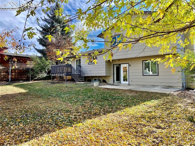 back of house featuring a lawn and a patio area