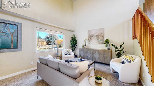 carpeted living room featuring a towering ceiling