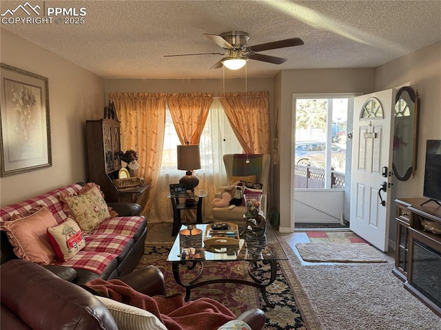 living room with ceiling fan, plenty of natural light, and a textured ceiling