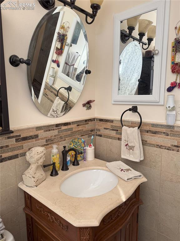 bathroom featuring vanity and tile walls