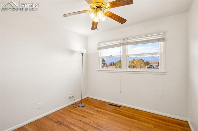 spare room with ceiling fan and wood-type flooring