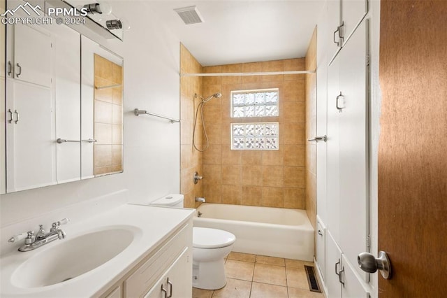 full bathroom with toilet, tile patterned flooring, vanity, and tiled shower / bath