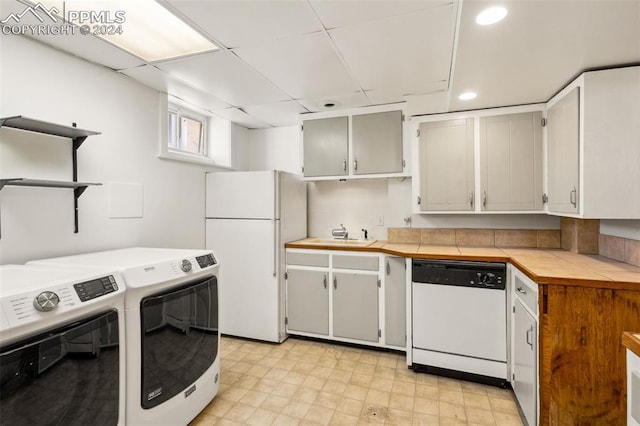 kitchen featuring separate washer and dryer, sink, and white appliances