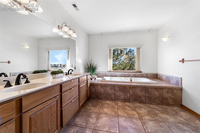 bathroom featuring tile patterned floors, vanity, and tiled tub