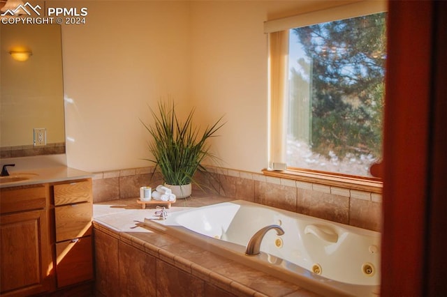 bathroom featuring tiled tub and vanity