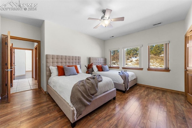 bedroom with dark hardwood / wood-style floors and ceiling fan