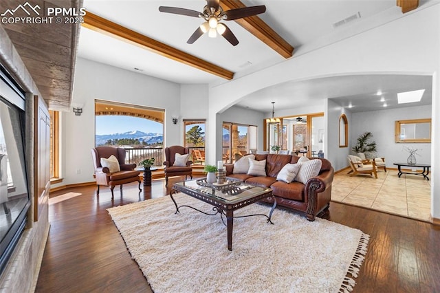 living room featuring beam ceiling, ceiling fan, and dark wood-type flooring