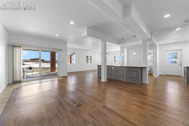 unfurnished living room with hardwood / wood-style floors and an inviting chandelier